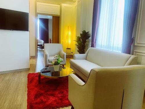 a living room with two white chairs and a red rug at Grand Lord Hotel & Residence - Khao chi chan Pattaya in Na Jomtien