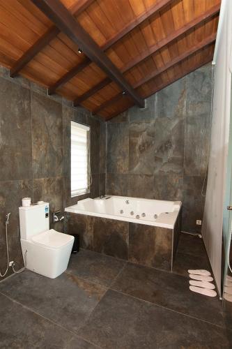 a bathroom with a bath tub and a toilet at River Arc in Panadura