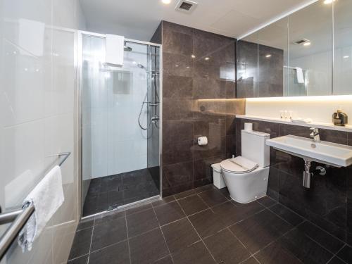 a bathroom with a shower and a toilet and a sink at Lvl 24 Family apartment in the heart of CBD by Stylish Stays in Brisbane