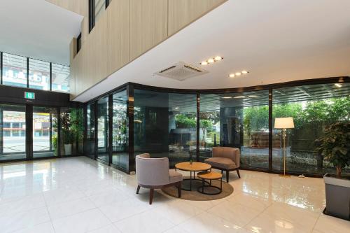 a lobby with a table and chairs in a building at JEJU Western Grace Hotel in Seogwipo