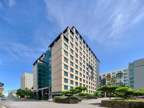 a tall building on a street in a city at JEJU Western Grace Hotel in Seogwipo