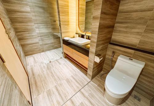 a small bathroom with a toilet and a sink at Grand Lord Hotel & Residence - Khao chi chan Pattaya in Na Jomtien