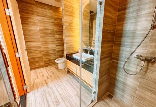 a bathroom with a shower with a toilet and a sink at Grand Lord Hotel & Residence - Khao chi chan Pattaya in Na Jomtien