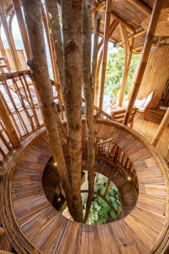 a spiral staircase with a tree in the middle at Cliffside Bamboo Treehouse with Heated Pool and View in Bungbungan