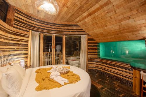 a bedroom with a bed with a teddy bear on it at Cliffside Bamboo Treehouse with Heated Pool and View in Bungbungan