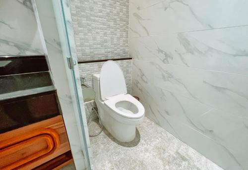 a bathroom with a white toilet and a shower at Grand Lord Hotel & Residence - Khao chi chan Pattaya in Na Jomtien