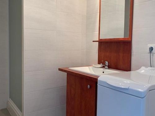 une salle de bain blanche avec un lavabo et un miroir dans l'établissement Appartement F3 avec balcon & terrasse, proche plage, 6 couchages - Narbonne Plage - FR-1-229B-23, à Narbonne