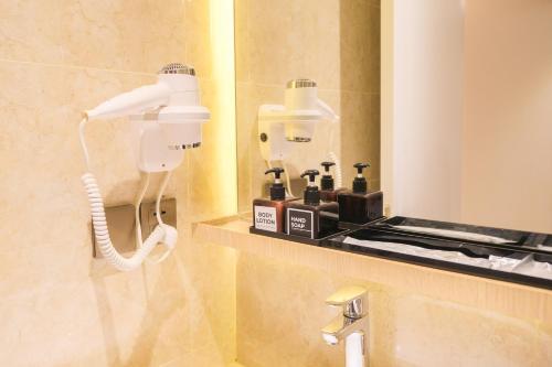 La salle de bains est pourvue d'un sèche-cheveux et d'un téléphone. dans l'établissement Pentacity Hotel Balikpapan, à Balikpapan