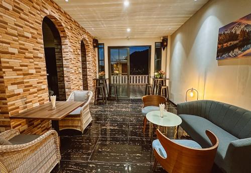 a restaurant with couches and tables and chairs at Grand Lord Hotel & Residence - Khao chi chan Pattaya in Na Jomtien