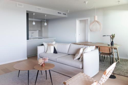 a living room with a white couch and a table at Suite Portus - Design apartment by the sea in Hanko