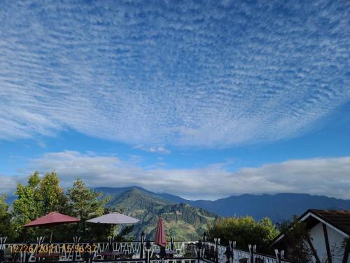 a blue sky with clouds and tables and umbrellas at Naluwan Villa in Renai