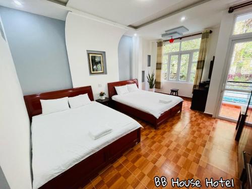 a bedroom with two beds and a large window at BB House Hotel Đ&agrave; Lạt in Da Lat