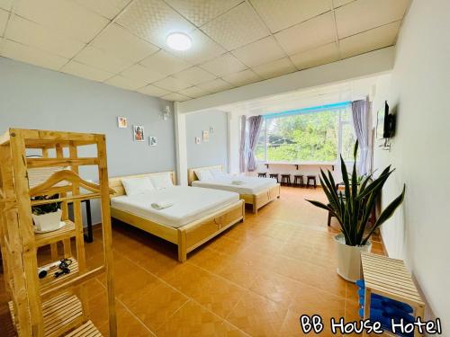 a living room with two beds and a window at BB House Hotel Đ&agrave; Lạt in Da Lat