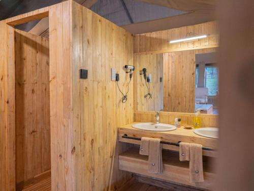a wooden bathroom with a sink and a mirror at Serengeti Kifaru Tented Lodge in Mugumu