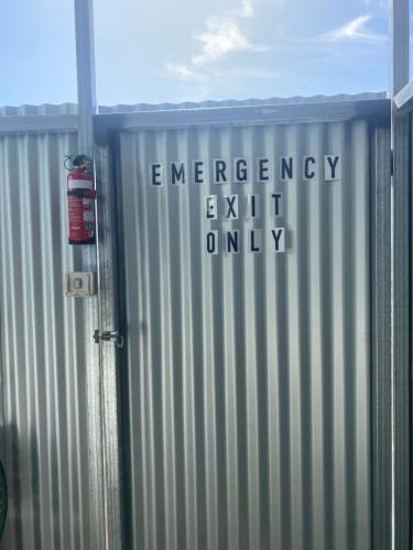 a metal fence with the words emergency exit only on it at Morros Place in Hay