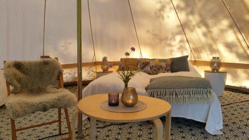 Lystang Glamping & Cabins في نوتودن: غرفة نوم بسرير وكرسي وطاولة