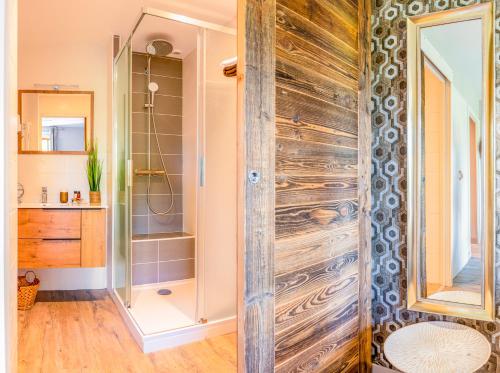 a bathroom with a shower and a wooden door at Hotel-Restaurant Le Sorgia in Bellegarde-sur-Valserine