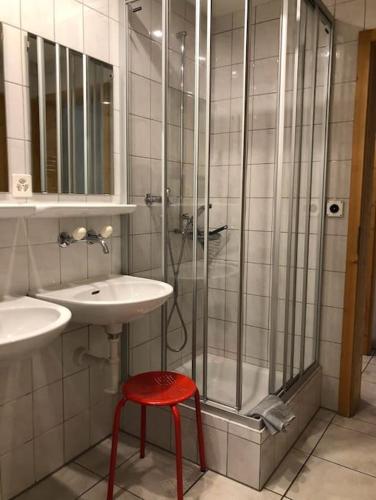 a bathroom with a sink and a shower with a red stool at Alte Sennerei in Ober-Says