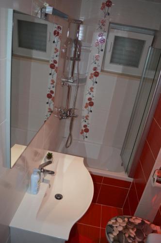 een badkamer met een wastafel, een toilet en een spiegel bij Apartments Iva in Makarska