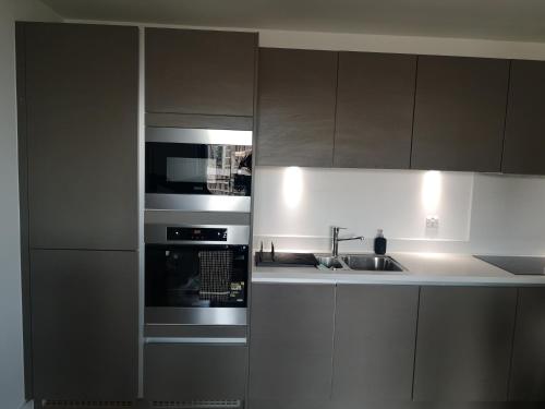 a kitchen with a microwave oven and a sink at Entire Flat - Modern Flat near Canary Wharf in London