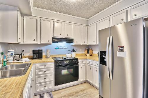 a kitchen with white cabinets and a stainless steel refrigerator at Beach &nightlife 3BR/2.5 BA service dog friendly in Myrtle Beach