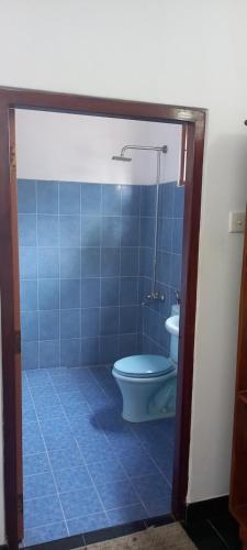a bathroom with a toilet and a blue tiled floor at Ocean View tourist guest house at Negombo beach near the airport in Negombo