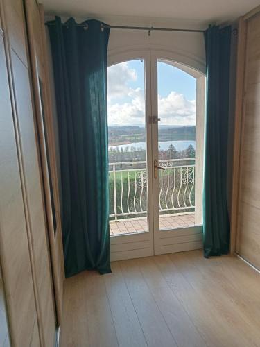 a room with a door and a window with a view at Vaste villa en position dominante superbe vue lacs in Hautecour