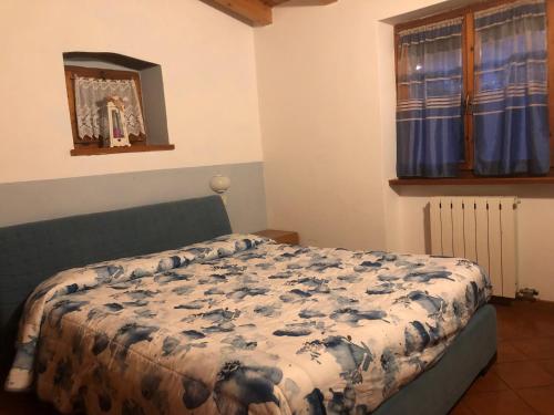 ブレンゾーネにあるAppartamento Lauraのベッドルーム1室(毛布付きのベッド1台付)