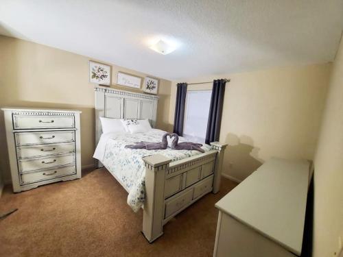 sypialnia z łóżkiem z komodą i oknem w obiekcie The Eclectic. Entire Apartment w mieście Anderson