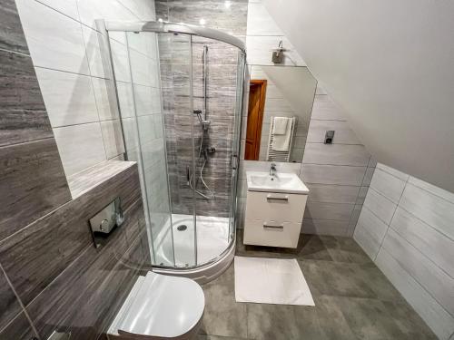 W łazience znajduje się prysznic, toaleta i umywalka. w obiekcie Gościniec Smrekowa Chata w mieście Glinka