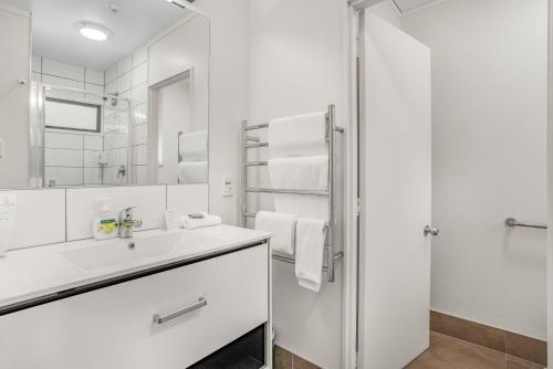 a white bathroom with a sink and a shower at Capital Lodge Motor Inn in Wellington