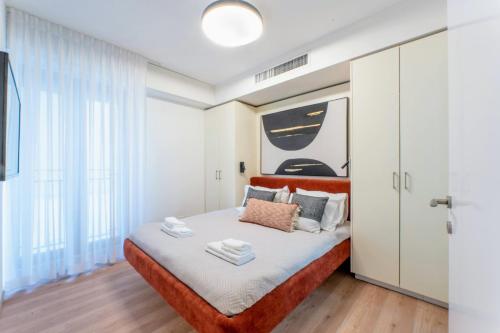 a bedroom with a bed with white walls and wood floors at Holysuite David's Village in Jerusalem