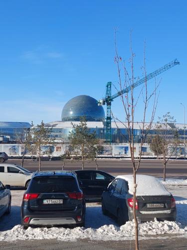 a group of cars parked in a parking lot at Отличная квартира напротив ЭКСПО in Astana