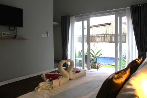 een slaapkamer met twee zwanen op een bed met een raam bij Fish Mini Authentic in Gianyar
