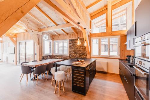 une cuisine avec une table et des chaises dans une pièce dans l'établissement Chalet M, pied des pistes et garage, à Montgenèvre