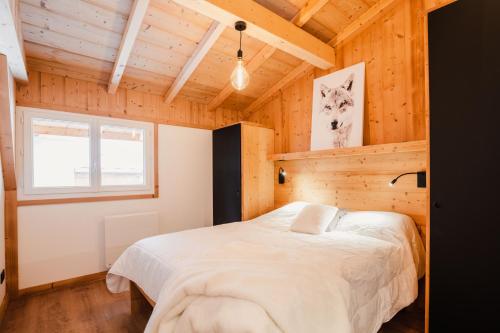 sypialnia z łóżkiem w drewnianym pokoju w obiekcie Chalet M, pied des pistes et garage w mieście Montgenèvre