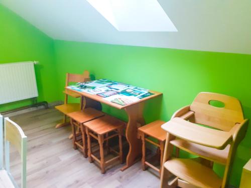 a room with a table and chairs in a room with green walls at Agroturystyka Pod Złotą Wiechą in Uście Gorlickie
