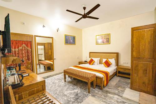 a bedroom with a bed and a desk and a ceiling at Hotel Chandrawati Palace in Ābu Road