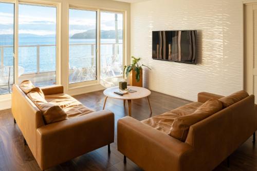 a living room with two couches and a table and windows at SETOUCHI SUP RESORT - Ao - in Shodoshima