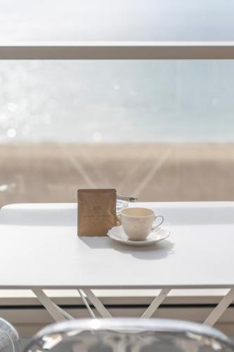 a cup of coffee sitting on a table next to a window at SETOUCHI SUP RESORT - Ao - in Shodoshima