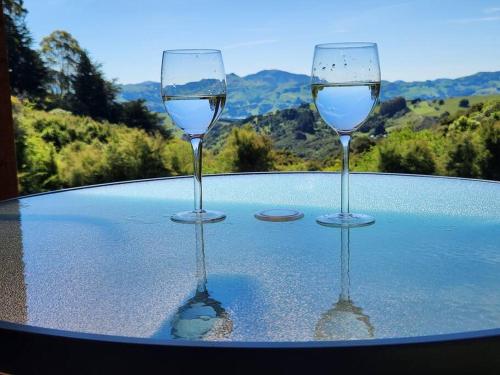 two glasses of white wine sitting on a table at Glenwood Akaroa Bush Retreat - Kanuka Hut in Akaroa