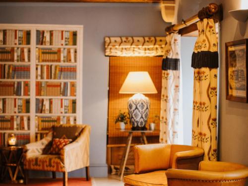 a living room with bookshelves and a chair and a lamp at The Old Hall Ely in Ely