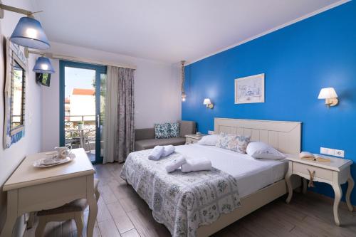 a bedroom with a bed and a blue wall at Villa Anthelion in Limenaria