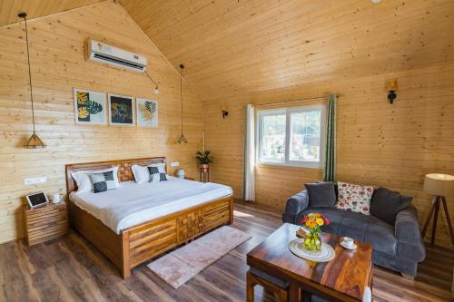 1 dormitorio con 1 cama y 1 sofá en una habitación en SaffronStays Cottage Glade, Dehradun - luxury wooden cottage, en Dehradun