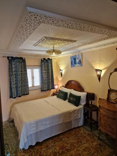 een slaapkamer met een bed en een raam bij Dar Khadija in Asilah