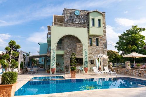 a hotel with a swimming pool in front of a building at Villa Anthelion in Limenaria