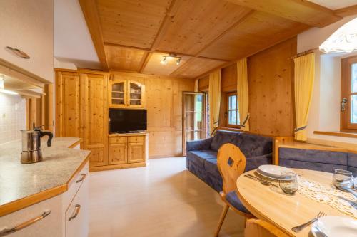 a kitchen and living room with a blue couch and a table at Grossgasteigerhof in Selva dei Molini