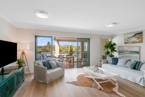 een woonkamer met een bank en een tafel bij Sunrise Cove- 2BR Waterfront Apartment by uHoliday in Kingscliff