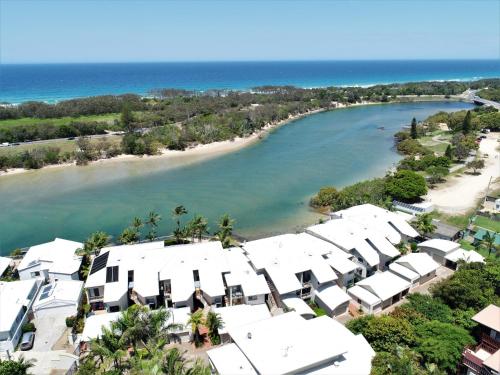 an aerial view of a beach with white buildings at Sunrise Cove- 2BR Waterfront Apartment by uHoliday in Kingscliff