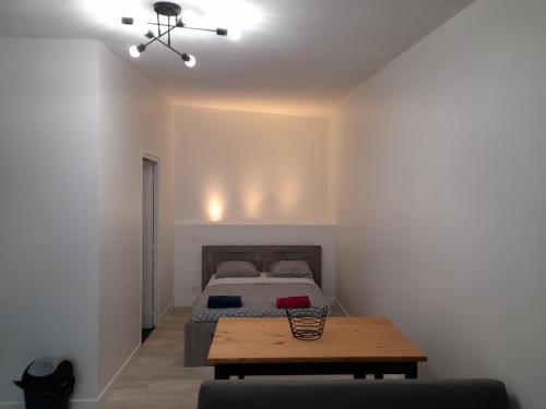 une chambre avec un lit et une table en bois dans l'établissement LE WANDA JAUNE, à Reims